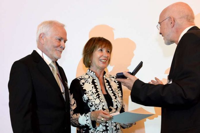 Prof. Dr. Thomas Puhl, Prorektor der Universität Mannheim, überreicht die Universitätsmedaille an Ulrike und Dr. Axel Weber. (Foto: Universität Mannheim)