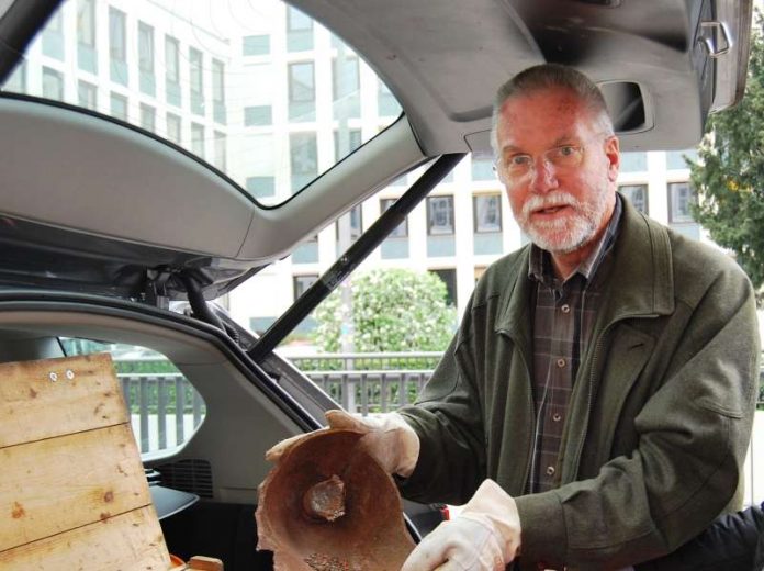 Gerhard Gossens zeigt eines seiner Fundstücke aus seiner Zeit beim Kampfmittelräumdienst in Darmstadt. Dieses wurde von einem Schmied zu einer Friedensskulptur verarbeitet. (Foto: Regierungspräsidium Darmstadt)