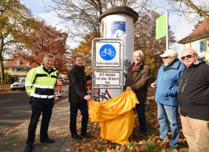 Neue Fahrradstraße: Bürgervereinsvorsitzender Peter Cernoch und Tiefbauamtsleiter Gerhard Schönbeck enthüllen im Beisein von Bewohnern der Nordstadt das Verkehrsschild „Fahrradstraße“. (Foto: Stadt Karlsruhe)