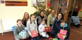 Vertreterinnen – und ein Vertreter – des Hohensachsener Weihnachtsmarkt-Komitees präsentieren gemeinsam mit Heimleiter und Pflegedienstleiterin die mitgebrachten Geschenke: Astrid Winkler (hinten links) mit Juliane, Julika und Melina, Sonja Beetz und Henning Hesselmann (Pflegedienstleiterin und Heimleiter des GRN-Betreuungszentrums Weinheim, beide hinten) und Maike Weinast (hinten rechts) mit Jonathan. (Foto: GRN)