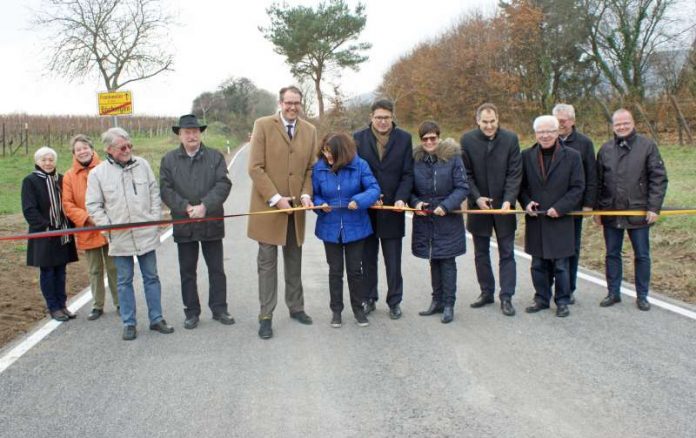 Feierliche Verkehrsfreigabe der K54: Landrätin Theresia Riedmaier (6.v.l.) durchtrennt gemeinsam mit Torsten Blank (7. v.l.) sowie Ortsbürgermeister Reinhold Walter (3.v.r.) und weiteren Ehrengästen das Band. (Foto: Kreisverwaltung Südliche Weinstraße)