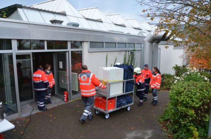 Helfer des Deutschen Roten Kreuzes und des Malteser Hilfsdienstes bringen bei der Katastrophenschutzübung Materialien für die Notfallunterbringung Evakuierter in die Turnhalle der BBS Bingen. (Foto: Kreisverwaltung Mainz-Bingen) Helfer des Deutschen Roten Kreuzes und des Malteser Hilfsdienstes bringen bei der Katastrophenschutzübung Materialien für die Notfallunterbringung Evakuierter in die Turnhalle der BBS Bingen. (Foto: Kreisverwaltung Mainz-Bingen)
