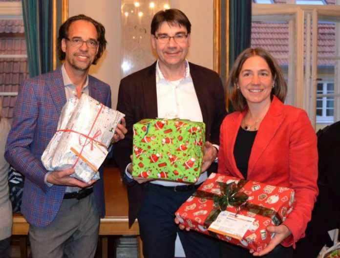 Oberbürgermeister Thomas Hirsch gemeinsam mit Kabarettist Christoph Sonntag (l.) und Susanne Burgdörfer vom Haus der Familie bei der feierlichen Geschenkeübergabe im historischen Empfangssaal des Landauer Rathauses. (Stadt Landau in der Pfalz)