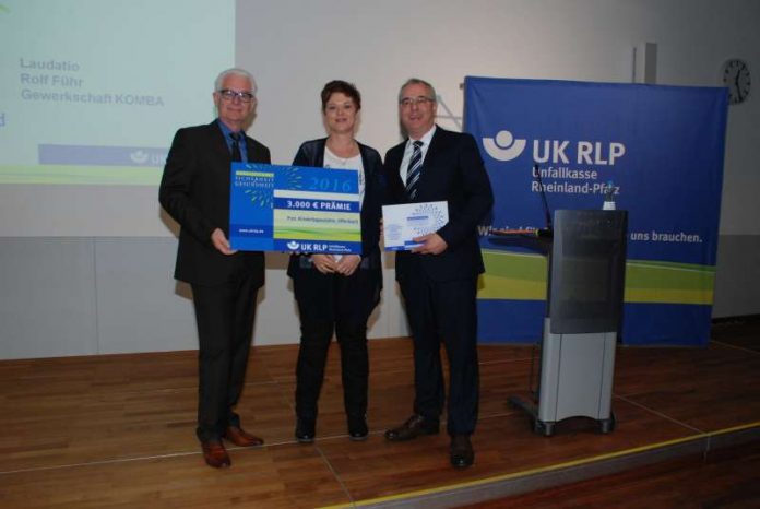 Geschäftsführer Manfred Breitbach (links) überreicht zusammen mit Rolf Führ, KOMBA, symbolisch einen Scheck an Tanja Lutz von der Prot. Kita Offenbach/Queich. (Foto: UK RLP)