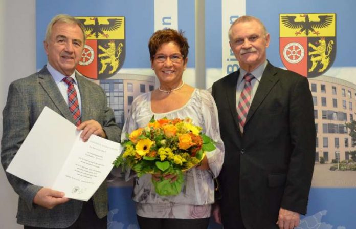 Landrat Claus Schick (links) und der Erste Kreisbeigeordnete Adam J. Schmitt (rechts) verabschieden Rosemarie Wenzel in den Ruhestand. (Foto: Kreisverwaltung Mainz-Bingen)