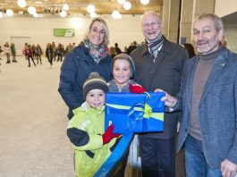 Freute sich riesig über sein Geschenk: Philipp (vorne links) mit seiner Mama und seinem Bruder Florian bekam als 10.000ster Besucher der diesjährigen Eisbahnsaison von Beigeordnetem Joachim Färber (2. v. r.) und Ortwin Kafitz von der SWK eine 12er-Eintrittskarte und ein Monopoly Kaiserslautern Brettspiel überreicht. (Foto: Martin Goldhahn / view)