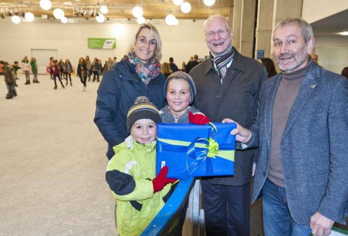 Freute sich riesig über sein Geschenk: Philipp (vorne links) mit seiner Mama und seinem Bruder Florian bekam als 10.000ster Besucher der diesjährigen Eisbahnsaison von Beigeordnetem Joachim Färber (2. v. r.) und Ortwin Kafitz von der SWK eine 12er-Eintrittskarte und ein Monopoly Kaiserslautern Brettspiel überreicht. (Foto: Martin Goldhahn / view)