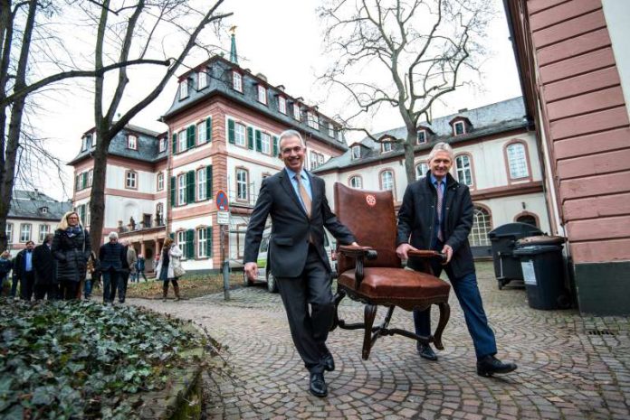 OB Peter Feldmann und Henning Brandt tragen Stuhl mit 'Mainzer Rad' (Foto: Heike Lyding)
