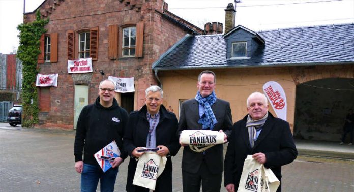 Thomas Beckmann und Markus Delnef vom Fanprojekt Mainz sowie Oberbürgermeister Michael Ebling und den Stadtwerke-Vorstandsvorsitzenden Detlev Höhne bei der Schlüsselübergabe sowie vor dem Gebäudetrakt des Fanprojekts auf dem Gelände des Alten Rohrlagers. (Foto: Mainzer Stadtwerke AG)