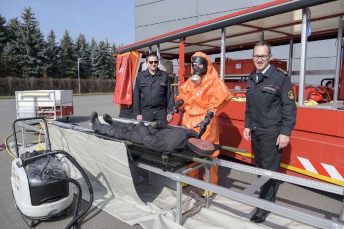 Zeigten an einer Puppe, wie eine verletzte Person in der „Reinigungsstraße“ durch Besprühen mit einer speziellen Flüssigkeit dekontaminiert wird (von links): Dirk Buchwald, Verantwortlicher bei der Feuerwehr Heidelberg für das Aufgabengebiet ABC-Gefahren, Feuerwehrmann Andreas Hormuth in Schutzkleidung und Dr. Georg Belge, Leiter der Feuerwehr Heidelberg. (Foto: Philipp Rothe)