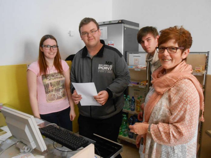 FAW-Ausbilderin Iris Rocker-Dingfelder mit den BVB-Teilnehmern des Praxisbereichs Lager/Handel beim „Kassentraining“ (Foto: FAW Mainz)