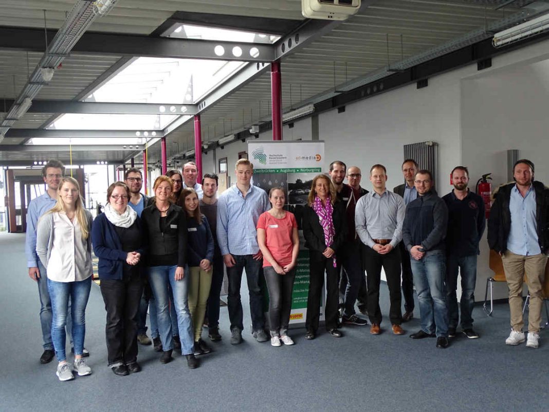 Mittagspause bei schönem Wetter am Nürburgring: Studierende mit den Frau Prof. Dr. Reuter und Herrn Prof. Dr. Ruda (Mitte) und Gastdozent Paul Strassl (rechts) (Foto: HSKL)