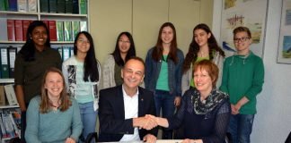 Oberstudienrätin Andrea Frick, Landrat Dr. Fritz Brechtel und Schulleiterin Ariane Ball bei der Vertragsunterzeichnung, im Hintergrund Schüler der Projektgruppe, sog. Energiescouts. (Foto: Kreisverwaltung Germersheim)