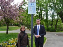 Bürgermeister und Ordnungsdezernent Dr. Maximilian Ingenthron und Sabine Klein, Leiterin der städtischen Grünflächenabteilung, präsentieren die neuen Hinweisschilder für die Familienbereiche im Ostpark. Die Bemühungen, das subjektive Sicherheitsgefühl der Parkbesucherinnen und -besucher zu verbessern, sind dezernats- und ämterübergreifend angelegt. (Foto: Stadt Landau in der Pfalz)