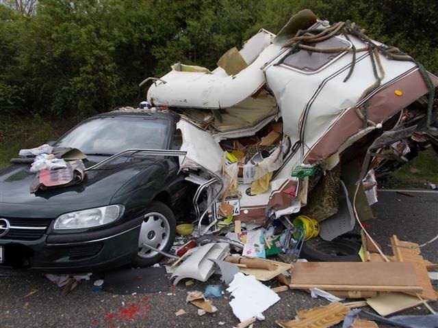 Pannenfahrzeug mit zerstörtem Wohnwagen
