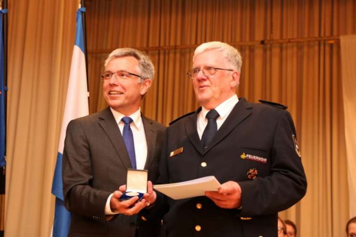 „Ein Feuerwehrmann mit Leib und Seele“ geht in den Ruhestand: Landrat Stefan Dallinger (l.) zeichnet Kreisbrandmeister Peter Michels (r.) mit der silberne Ehrenmedaille des Rhein-Neckar-Kreise aus. (Foto: Kreisfeuerwehrverband)