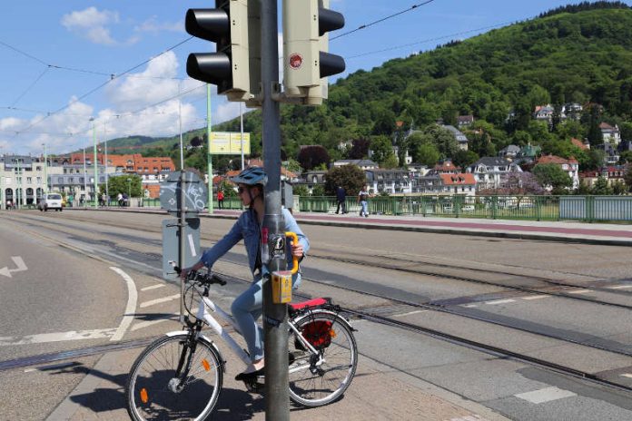 Mehr Komfort für Radler: Die Stadt Heidelberg installierte 43 gelbe Ampelgriffe an sieben wichtigen Straßenkreuzungen, sodass Radfahrerinnen und Radfahrer nicht vom Rad absteigen müssen, während sie auf „Grün“ warten. (Foto: Stadt Heidelberg)