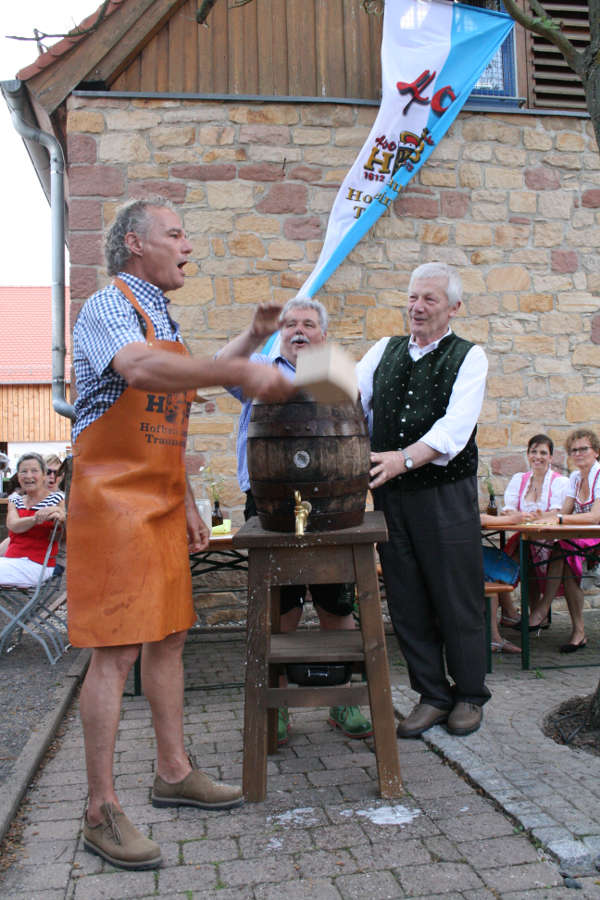 „Ozapf’t is“ rief Bürgermeister Axel Wassyl vor zwei Jahren beim letzten Traunsteiner Bierfest nach nur zwei Schlägen. Beobachtet wurde das Geschehen von Traunsteins stv. Bürgermeister Hans Zillner (Rechts) und Brauerei-Chef Bernhard Sailer. (Foto: Queichtalmuseum Offenbach)