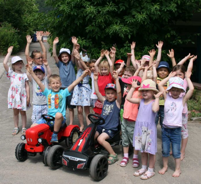 Die Kids mit einem Traktor und einem Kettcar (Foto: Förderverein KiTa Esthal)