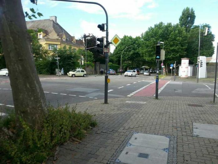 Der gelbe Kleinwagen ist an der Front tief eingedrückt. Der Streifenwagen steht an der Mauer