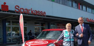 Andreas Ott, Vorsitzender des Vorstandes der Sparkasse Rhein-Haardt mit der Gewinnerin Renate Freymeyer vor dem symbolisch bereitstehenden MINI One – zur Verfügung gestellt durch das Autohaus Klaus Scheller. (Foto: Sparkasse Rhein-Haardt)
