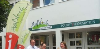 Ein echter Hingucker! Die Leiterin der Tourist-Information Annika Weiss, Mitarbeiterin Kathrin Zöller und der zuständige Beigeordnete Tobias Meyer freuen sich über das neue Schild (Foto: Gemeindeverwaltung Haßloch)