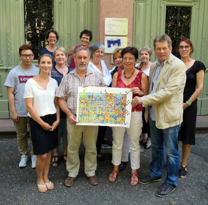 Die Mitarbeiterinnen und Mitarbeiter der VHS freuen sich über die Zertifizierung, als Zeichen der Anerkennung erhielten sie ein Bild. (Foto: Stadtverwaltung Neustadt)