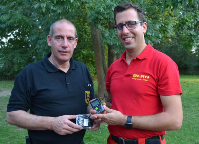 Der Landauer Stadtfeuerwehrinspekteur Dirk Hargesheimer (l.) und Simon Nichterlein, Technischer Leiter der DLRG Ortsgruppe Landau, bei der Übergabe der digitalen Funkmeldeempfänger an das DLRG. (Foto: Stadt Landau in der Pfalz)