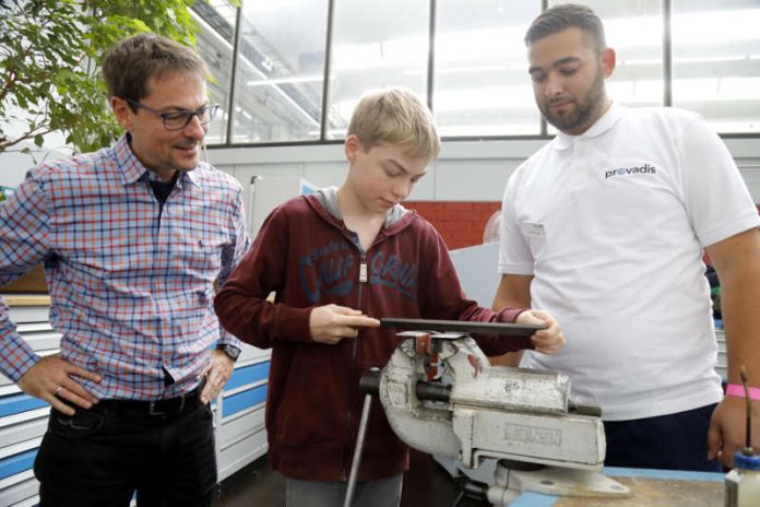 Jascha Pech (Mitte) darf an der Station „Feilen wie ein Profi“ unter Aufsicht seines Vaters Bernhard Pech (l.) und dem Auszubildenden Tarkan Sürcek (r.) selber ausprobieren. (Foto: 2017 Provadis Partner für Bildung und Beratung GmbH)