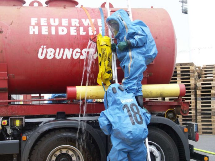 Ein Szenario bei der Großübung: Bei einem Chemieunfall läuft aus einem Tankfahrzeug ein Stoff aus, der mit anderen Gefahrstoffen reagiert. Die Feuerwehr greift mit speziellen Schutzanzügen ein. (Foto: Henkel)