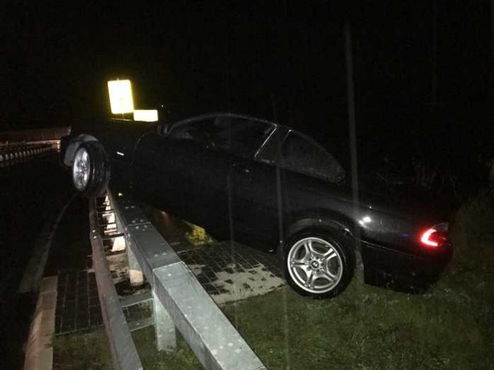 Verunfalltes Fahrzeug auf dem Brückengeländer