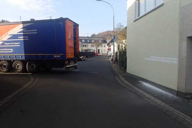 Heck des LKW mit Schaden am Haus