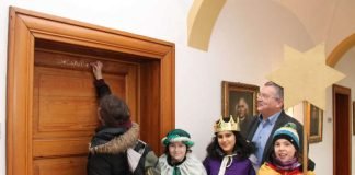 Sternsinger aus der Dompfarrer Pax Christi bringen den Segen in das Bischöfliche Ordinariat in Speyer. Mit Kreide schreiben sie auf die Tür zu den Arbeitszimmern von Generalvikar Dr. Franz Jung und Kanzleidirektor Wolfang Jochim (im Bildhintergrund) den Segensspruch „Christus mansionem benedicat – Christus segne dieses Haus“. (Foto: Bistum Speyer)