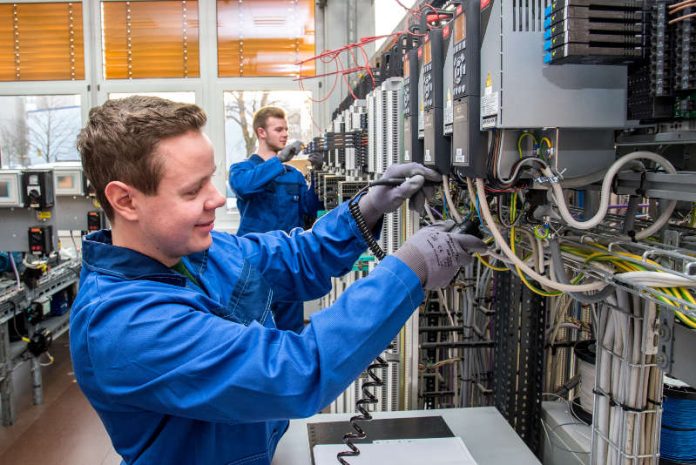 BASF-Auszubildende bei ihrer Arbeit: Jonathan Brand (vorne) und Philipp Lehmann (beide Auszubildende zum Elektroniker für Automatisierungstechnik) prüfen einen Frequenzumrichter. Das erwartet auch die neuen Auszubildenden mit Schwerpunkt Betriebstechnik. (Foto: BASF SE) BASF-Auszubildende bei ihrer Arbeit: Jonathan Brand (vorne) und Philipp Lehmann (beide Auszubildende zum Elektroniker für Automatisierungstechnik) prüfen einen Frequenzumrichter. Das erwartet auch die neuen Auszubildenden mit Schwerpunkt Betriebstechnik. (Foto: BASF SE)