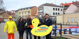 Drücken dem Kinderschutzbund für ein erfolgreiches Entenrennen die Daumen: (v.r.) Oberbürgermeister Thomas Hirsch, Geschäftsführer Heinrich Braun, Christian Schmitt und Birgit Merling vom Spielwarengeschäft „Wunschträume“ samt Wanderpokal für 622 verkaufte Adoptionsurkunden und die kostümierte Ente der Caritas (Copyright: DKSB)