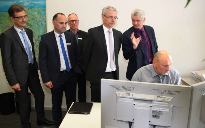 Projektverantwortlicher Stefan Brunner (rechts) erläutert Landrat Dr. Christoph Schnaudigel (3.v.r) die neue elektronische Akte im Bereich der Versorgungsverwaltung. Auf dem Bild weiter zusehen Finanzdezernent Ragnar Watteroth, Amtsleiter Versorgung und Rehabilitation Dieter Zimmermann, Amtsleiter Personal- und Organisation Ulrich Max, Sozialdezernent Peter Kappes. (Foto: Landratsamt Karlsruhe) Projektverantwortlicher Stefan Brunner (rechts) erläutert Landrat Dr. Christoph Schnaudigel (3.v.r) die neue elektronische Akte im Bereich der Versorgungsverwaltung. Auf dem Bild weiter zusehen Finanzdezernent Ragnar Watteroth, Amtsleiter Versorgung und Rehabilitation Dieter Zimmermann, Amtsleiter Personal- und Organisation Ulrich Max, Sozialdezernent Peter Kappes. (Foto: Landratsamt Karlsruhe)