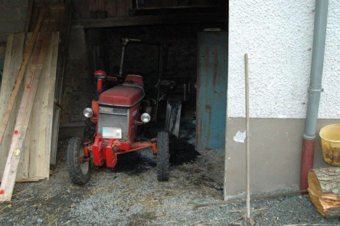 Durch das Feuer wurden ein Traktor und Teile der Scheune beschädigt. (Foto: Polizei RLP)