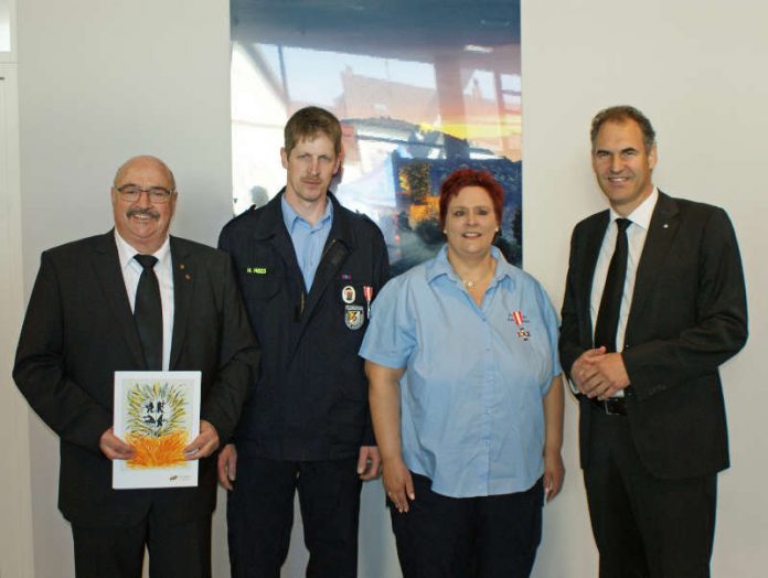 Landrat Dietmar Seefeldt (re.) und Kreisbeigeordneter Helmut Geißer (li.) und die mit dem silbernen Feuerwehr-Ehrenzeichen am Bande ausgezeichneten Anja Bertram-Mees und Heiko Mees. (Foto: Kreisverwaltung Südliche Weinstraße)