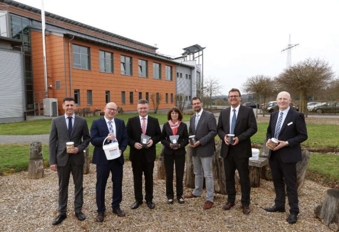 Die Landräte des Dreiländerecks informierten sich bei der Kreislaufwirtschaft Neckar-Odenwald (KWiN) in Buchen über aktuelle Projekte. Das Gruppenfoto mit innovativen Produkten wie Pflanzenkohle und Nährhumus aus dem Biomassezentrum fand im so genannten „Grünen Klassenzimmer“ des Energiegartens vor dem KWiN -Gebäude statt. (Foto: KWiN, Martin Hahn)