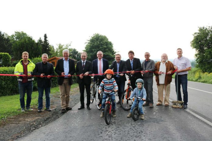 Der Radweg zwischen Rommersheim und Armsheim ist eröffnet: Bei Regenwetter zerschnitten die Ehrengäste das rote Band. (Foto: Simone Stier)