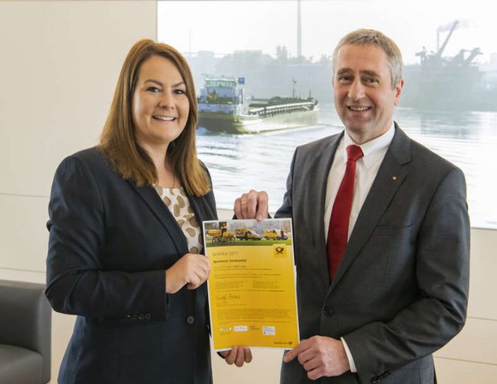 Die Vertriebsmanagerin der Deutschen Post AG Romy Patzwahl überreicht das GoGreen-Zertifikat an Sparkassen-Chef Thomas Traue. (Foto Sparkasse Vorderpfalz / Klaus Venus)