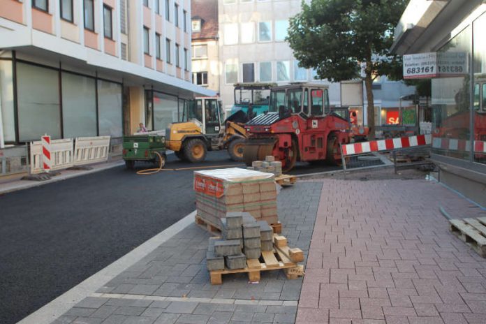 Das Pflaster ist verlegt. Heute beginnen die Arbeiter mit dem Einbau der Asphaltschicht in der Bahnhofstraße. Angesichts der hochsommerlichen Temperaturen eine schweißtreibende Angelegenheit. Die schwarze Masse hat beim Verlegen eine Temperatur von über 150 Grad Celsius. (Foto: Stadtverwaltung Pirmasens)