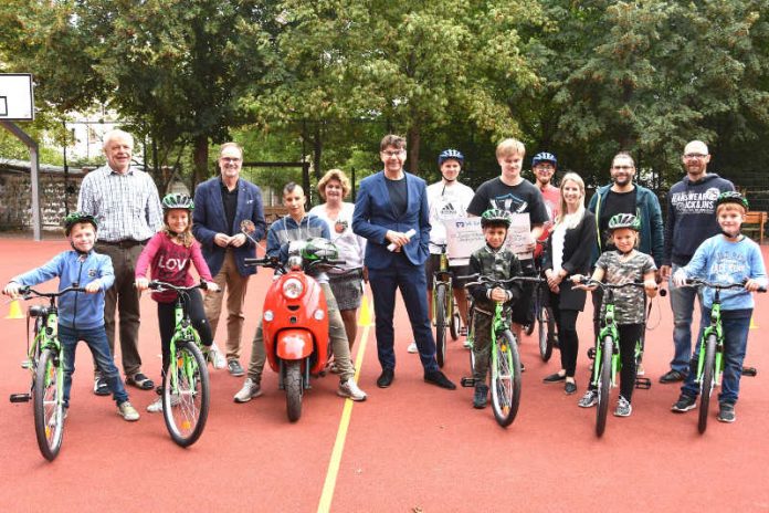 Oberbürgermeister Thomas Hirsch (M.), Landtagsabgeordneter Wolfgang Schwarz (2.v.l.) und Schulleiterin Angelika Bühler (3.v.l.) gemeinsam mit Lehrern und Mitgliedern des Mofa-Kurses und der Fahrradwerkstatt bei der kleinen Feierstunde auf dem Schulhof der Nordringschule. (Foto: Stadt Landau in der Pfalz)