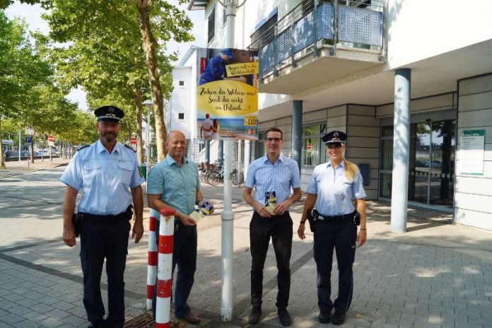 Jörg Hofmann, Ronald Daum, Sebastian Schrempp und Susann Benter (v.l.) hängen das erste Plakat am Rathaus Mitte gemeinsam auf. (Foto: Stadt Rheinstetten)