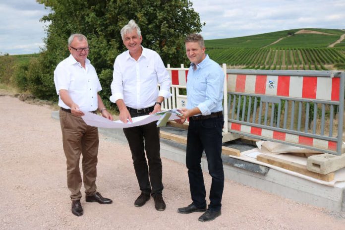 Landrat Ernst Walter Görisch, Bernhard Knoop und Thomas Finger (Kreisverwaltung, v.l.) begutachten vor Ort den erneuerten Durchlass. (Foto: Simone Stier)