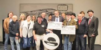 Ehemalige und aktive Musiker von „Les Patrons“ überreichen die Spendenschecks an Oberbürgermeister Thomas Feser. Foto: Stadt Bingen