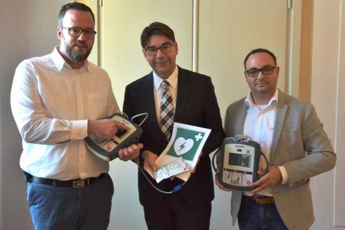 Oberbürgermeister Thomas Hirsch (M.) hat die neuen Defibrillatoren gemeinsam mit Landaus DRK-Vizepräsident und Notarzt Peter Wollny (l.) sowie dem Leiter der städtischen Personalabteilung, Alexander Kirchmer (r.), in Augenschein genommen. (Quelle: Stadt Landau in der Pfalz)