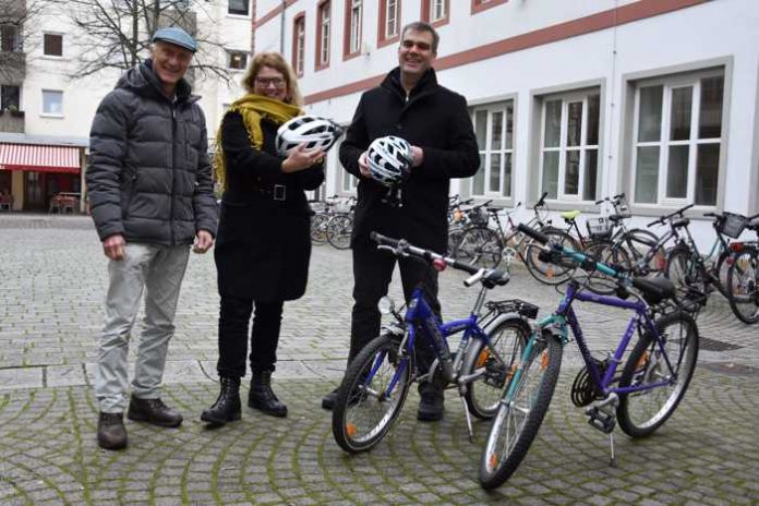 Der Vorsitzende des ADFC Landau/Südliche Weinstraße, Michael Schindler, und die städtische Gleichstellungsbeauftragte Evi Julier gemeinsam mit dem Pressesprecher der MTS-Group, Thorsten Kornmann, bei der Übergabe der Fahrradhelme (v.l.n.r.). (Quelle: Stadt Landau in der Pfalz)