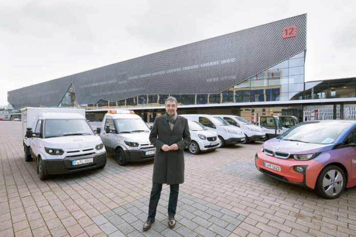 Uwe Behm, Geschäftsführer der Messe Frankfurt, und der messeinterne Fuhrpark an Elektrofahrzeugen. Darunter vertreten die Transportfahrzeuge des Typs StreetScooter und ein BMW i3. (Foto: Messe Frankfurt)