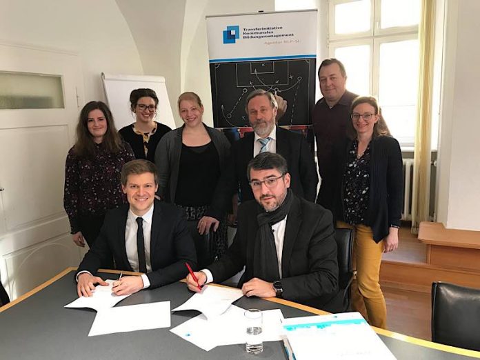 Oberbürgermeister Marc Weigel (u. r.) und Hanno Weigel (u. l.) von der Transferagentur unterzeichnen die neue Zielvereinbarung. Außerdem auf dem Foto: Das Bildungsbüro (Luise Forger, h. l.; Ann Kristin Langenbahn, 3. v. l. und Stefanie Deutsch, h. r.) und der zuständige Dezernent Markus Penn (2. v. r.) sowie der Fachbereichsleiter für Bildung, Kultur und Sport Rolf Müller (3. v. r.). (Foto. Stadtverwaltung Neustadt) Oberbürgermeister Marc Weigel (u. r.) und Hanno Weigel (u. l.) von der Transferagentur unterzeichnen die neue Zielvereinbarung. Außerdem auf dem Foto: Das Bildungsbüro (Luise Forger, h. l.; Ann Kristin Langenbahn, 3. v. l. und Stefanie Deutsch, h. r.) und der zuständige Dezernent Markus Penn (2. v. r.) sowie der Fachbereichsleiter für Bildung, Kultur und Sport Rolf Müller (3. v. r.). (Foto. Stadtverwaltung Neustadt)